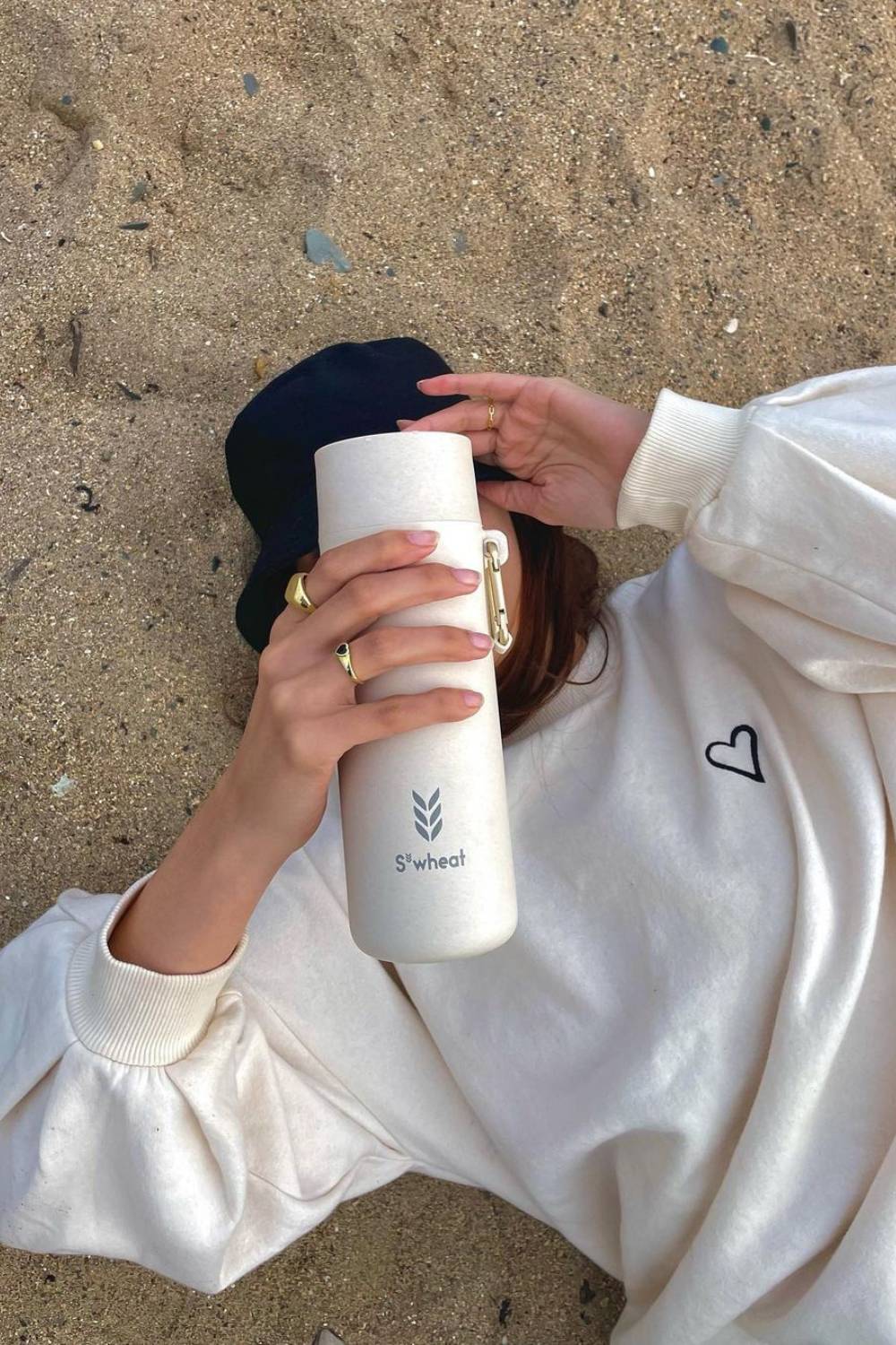 Sustainable bottle held by girl on sand