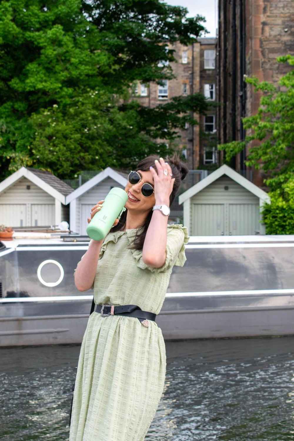 Green reusable drinks bottle held by woman