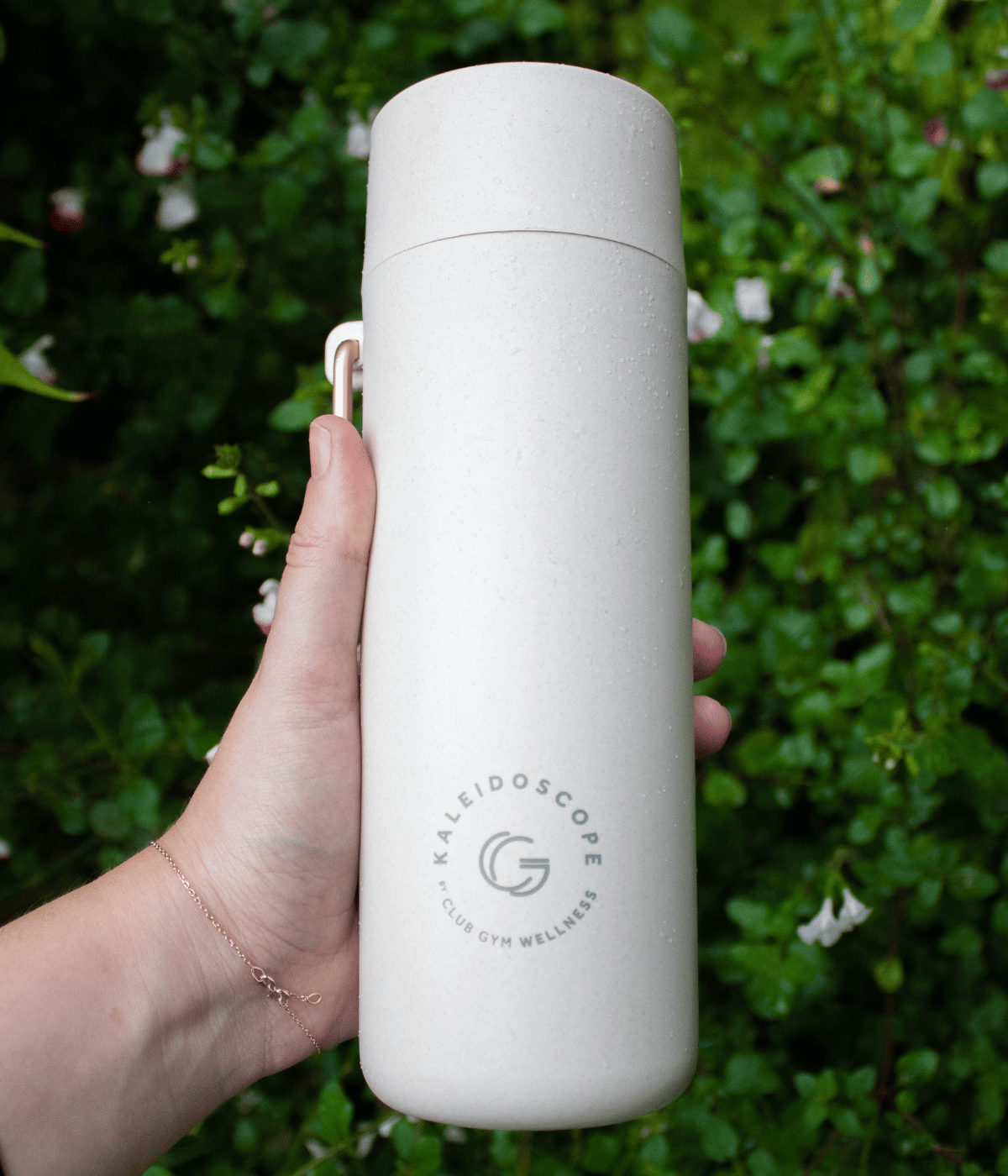 water bottle with logo next to trees